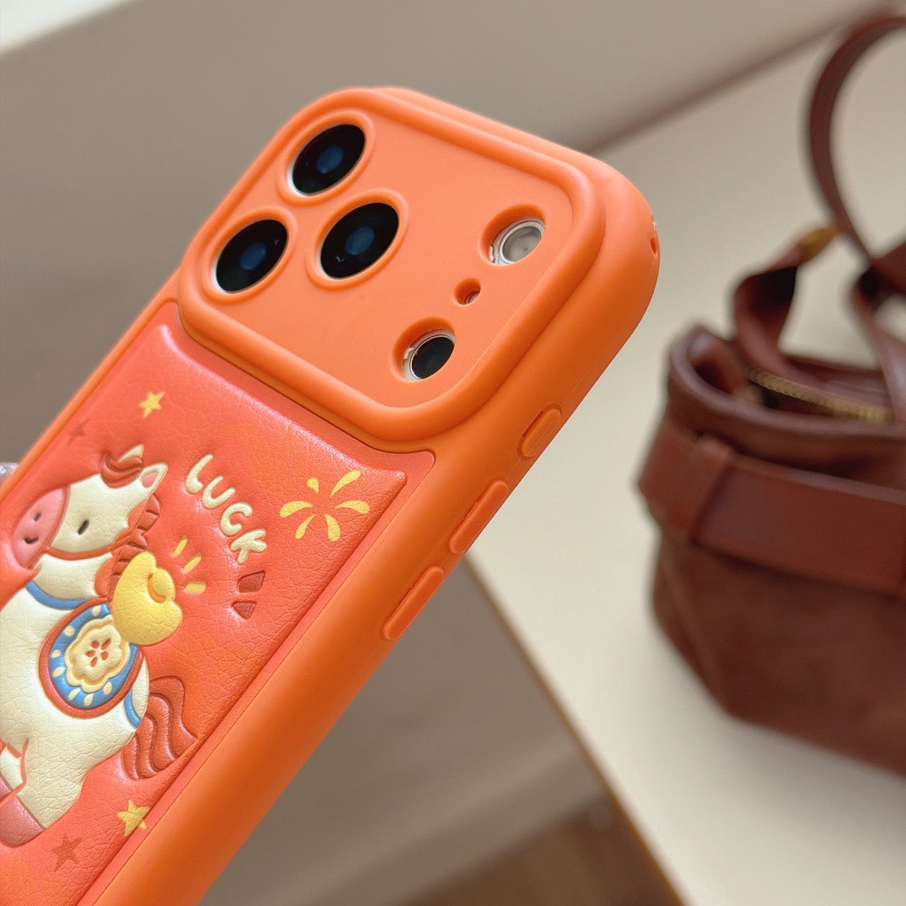 Orange-based 3D Apple phone case with gold ingot and pony design