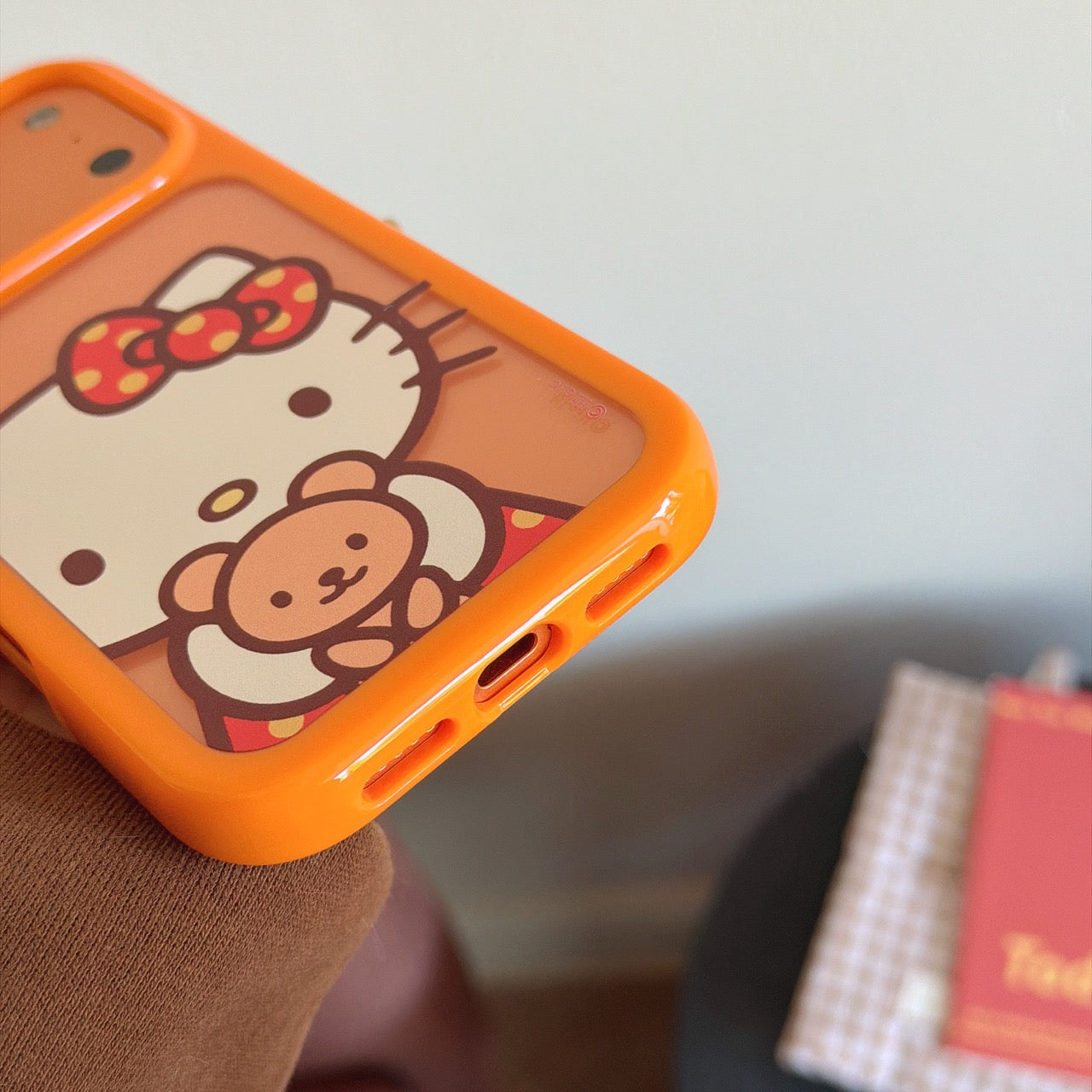 Orange-bordered Kitty hugging a bear rounded phone case