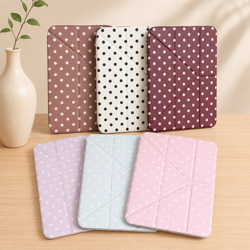 A studio product shot showcasing an aesthetic 6 color ipad case collection arranged neatly on a wooden desk next to a minimal white ceramic vase.