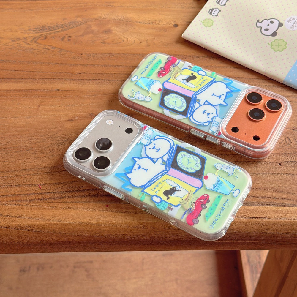 Two clear protective phone cases with a whimsical white cat and car illustration lying flat on a wooden bench.