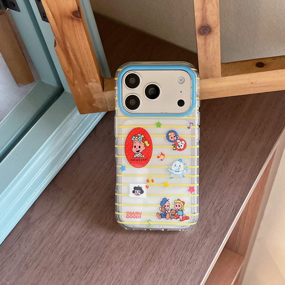 A cute Osamu Goods yellow striped phone case leaning vertically against a brown wooden frame.