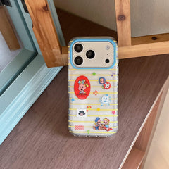 A cute Osamu Goods yellow striped phone case leaning vertically against a brown wooden frame.