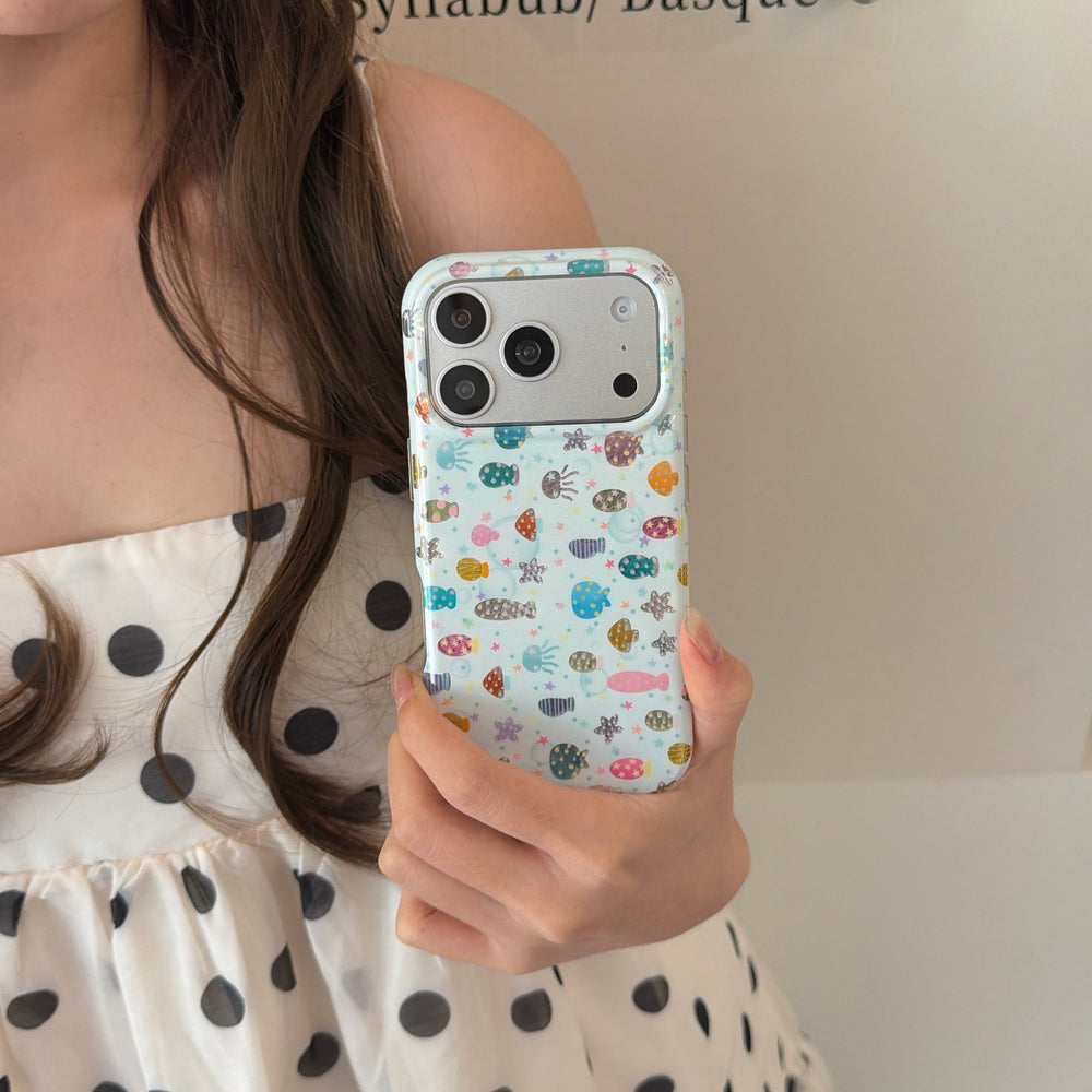 Mirror selfie of a woman showing the back of an aesthetic sea life clear phone case with a polka dot dress.