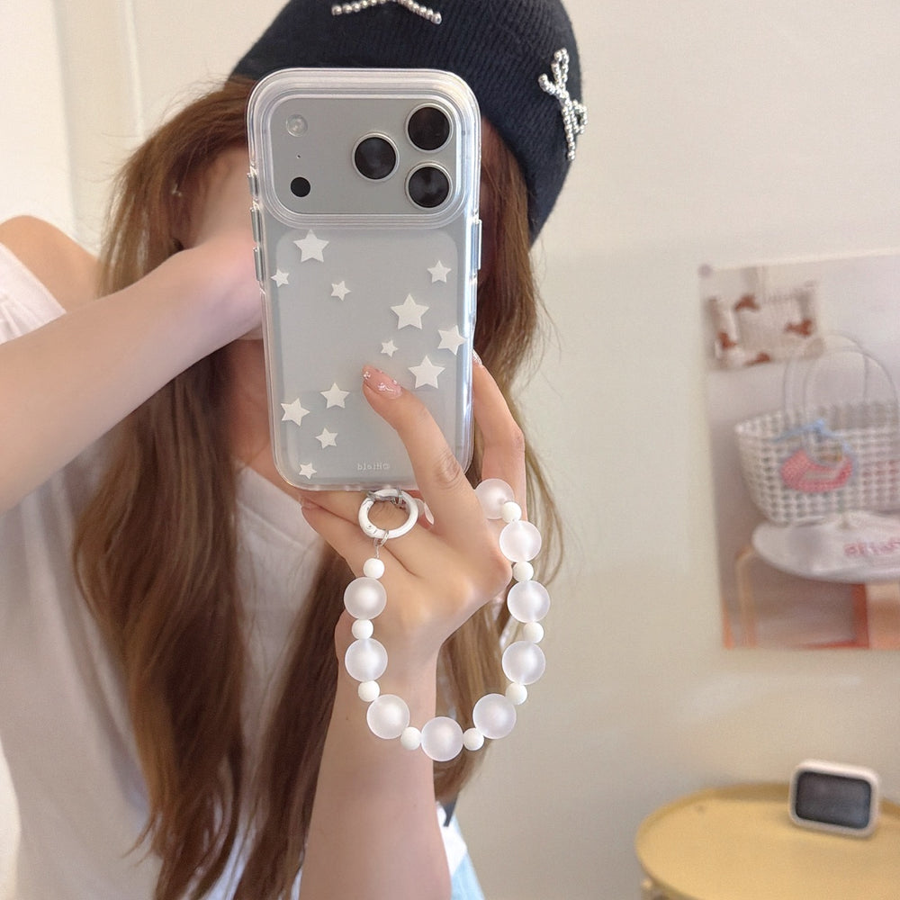 A close-up mirror selfie showing a clear Y2K star phone case with a translucent matte bead bracelet strap.