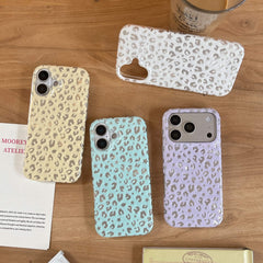Four colorful aesthetic Y2K star leopard iPhone cases in beige, white, mint green, and lavender on a wooden table.