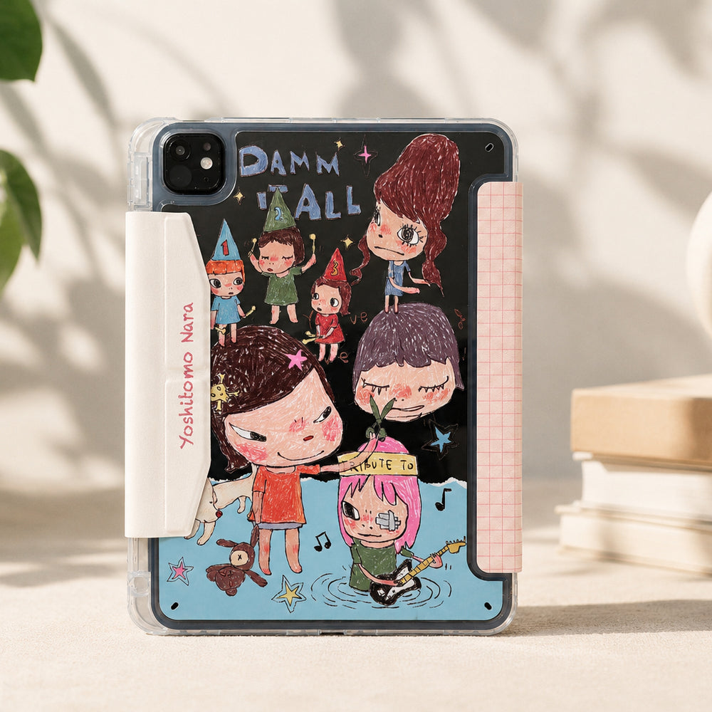 An aesthetic lifestyle display of a Yoshitomo Nara art iPad case with a shockproof clear back shell showing whimsical cartoon illustrations. The case stands vertically on a warm-toned textured surface with dappled leaf shadows, flanked by a green houseplant, stacked hardcover books, and a ceramic vase.