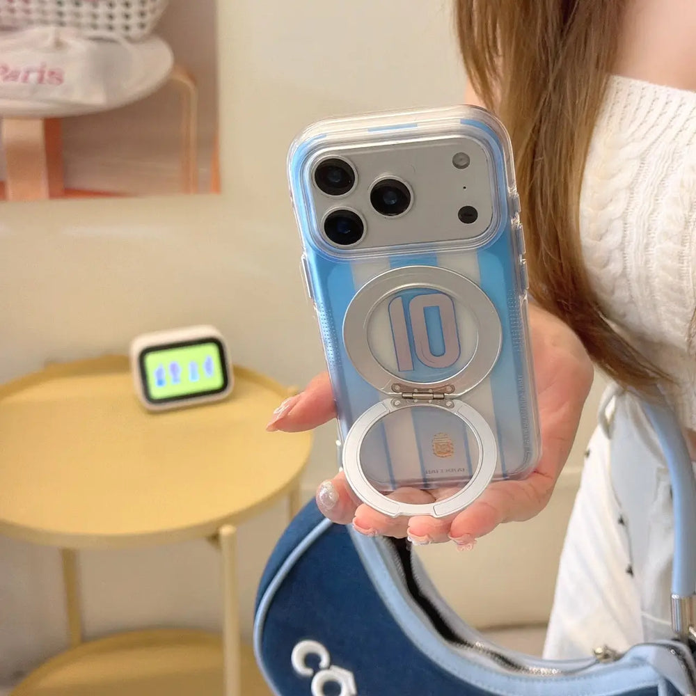 A woman holding a blue Argentina football jersey iPhone case using the flipped-out silver ring holder.