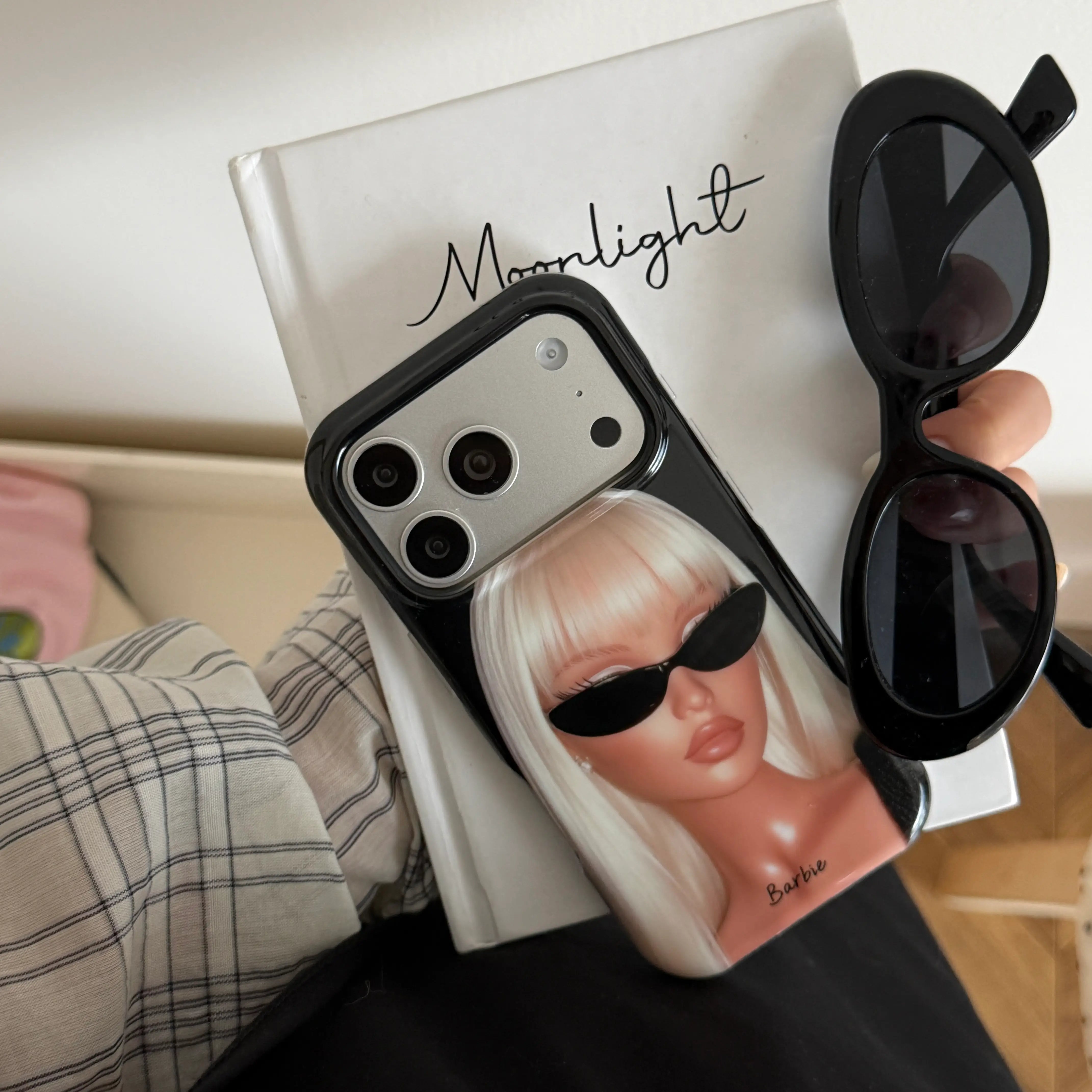 Black fashion girl iPhone case displayed beside matching sunglasses.