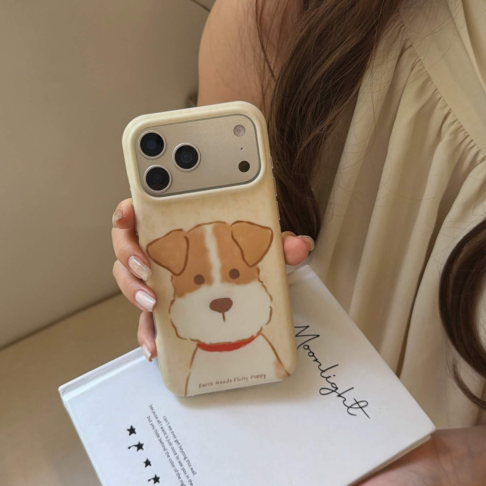 Brown and white puppy iPhone case displayed above a white lifestyle book.