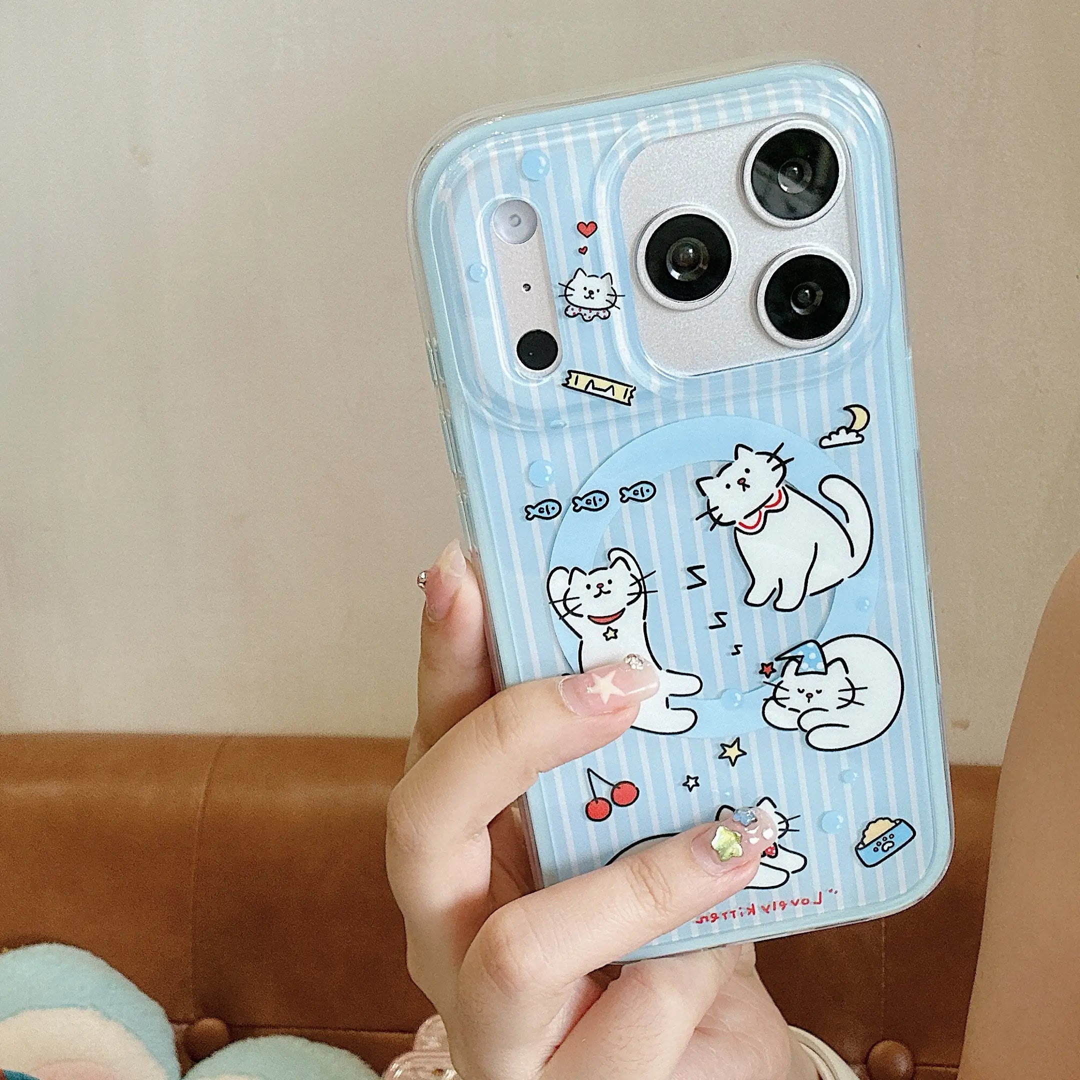 Hand holding a blue iPhone case with cat-shaped grip.