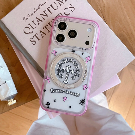 A Chrome Hearts inspired pink cross phone case with a built-in stand resting on a book.