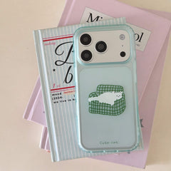 A clear aesthetic mint green lazy cat iPhone case resting on top of stacked pastel books.