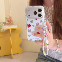 Mirror selfie showcasing a clear floral dopamine phone case with a pastel beaded phone lanyard.