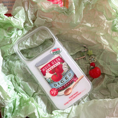A clear shockproof tomato design iPhone case packaged in green crinkled wrapping paper with its charm lanyard.