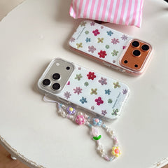 Two colorful floral clear phone covers displayed side-by-side on a round white table with a beaded strap.