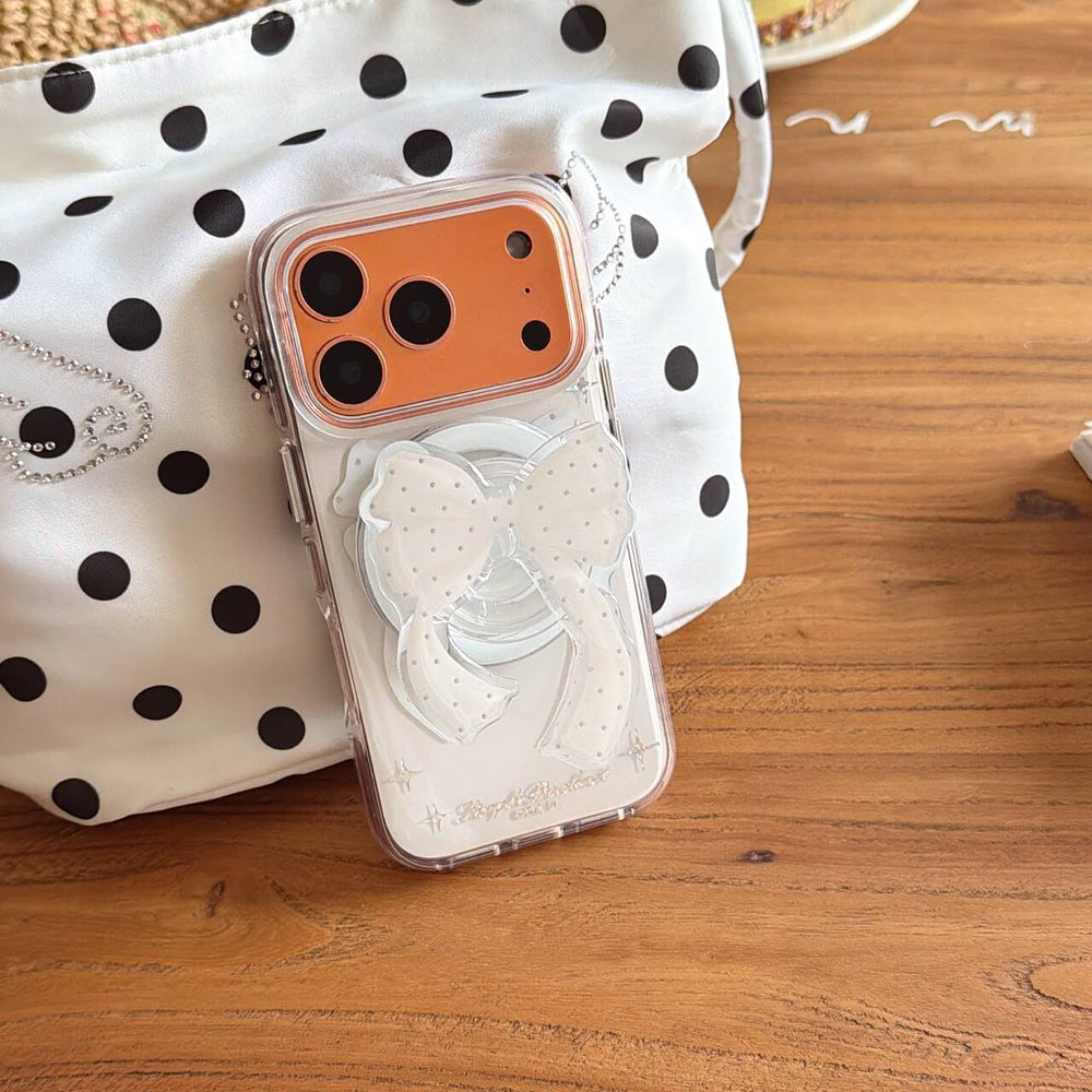 Coquette clear bow iPhone case beside polka dot bag