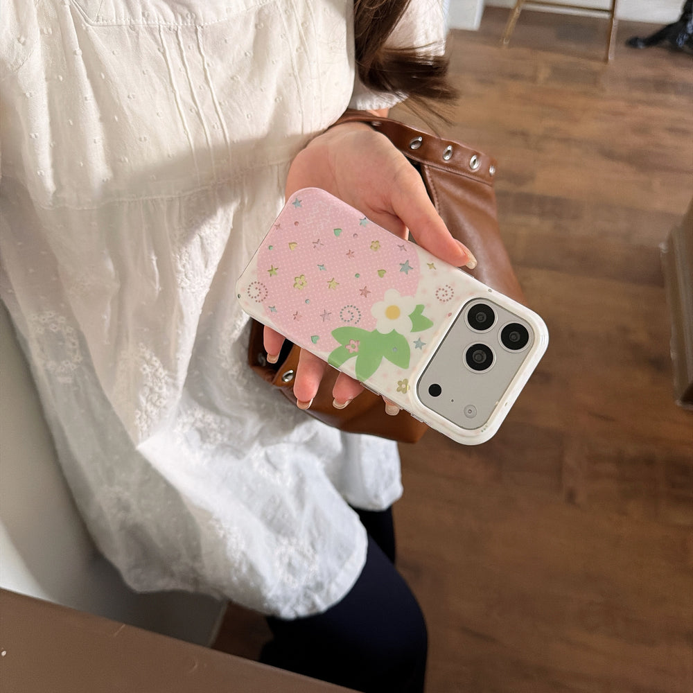 Side angle of a girl wearing a white lace blouse holding a cottagecore strawberry iPhone case over a brown leather shoulder bag.