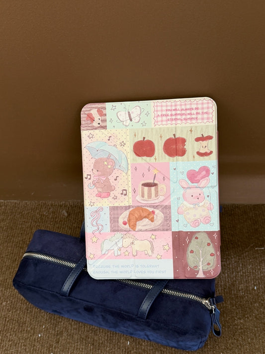 A closed cottagecore teddy bear iPad smart cover leaning vertically against a dark blue velvet pouch on a brown floor.