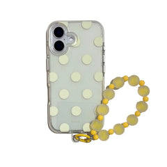 Studio view of a creamy yellow polka dot clear iPhone case with a matching frosted yellow jelly beaded wristlet strap.