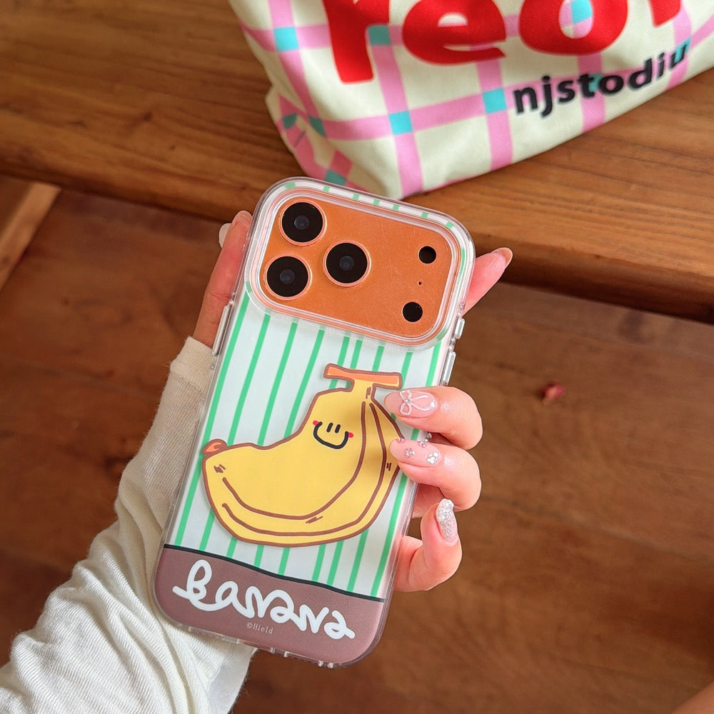 A hand holding an orange iPhone in a clear graphic case featuring a yellow smiling banana and a brown bottom banner.