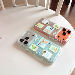 Two clear protective phone cases in green and orange with adorable dog illustrations lying on a white wooden chair.