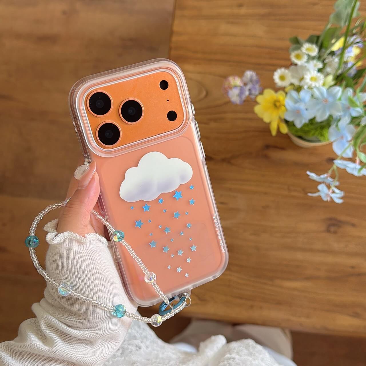 The cute 3D cloud star iPhone case neatly packaged inside a blue checkered gift box with its beaded charm.