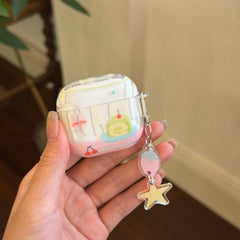 A hand holding a clear Kawaii cake AirPods Pro case with a strawberry and star charm keychain.