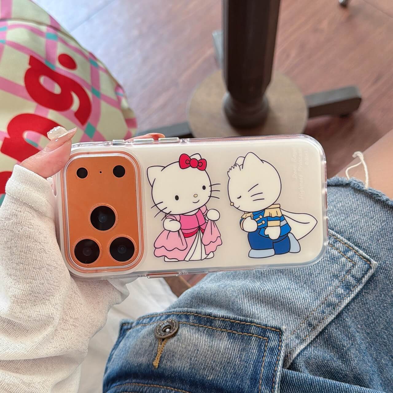 Handheld clear iPhone case featuring a royal kitty princess and prince couple