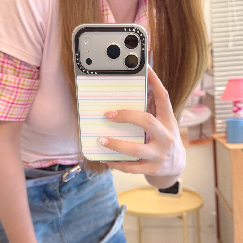A girl taking a mirror selfie holding a cute macaron pastel stripe iPhone case with a silver camera base.