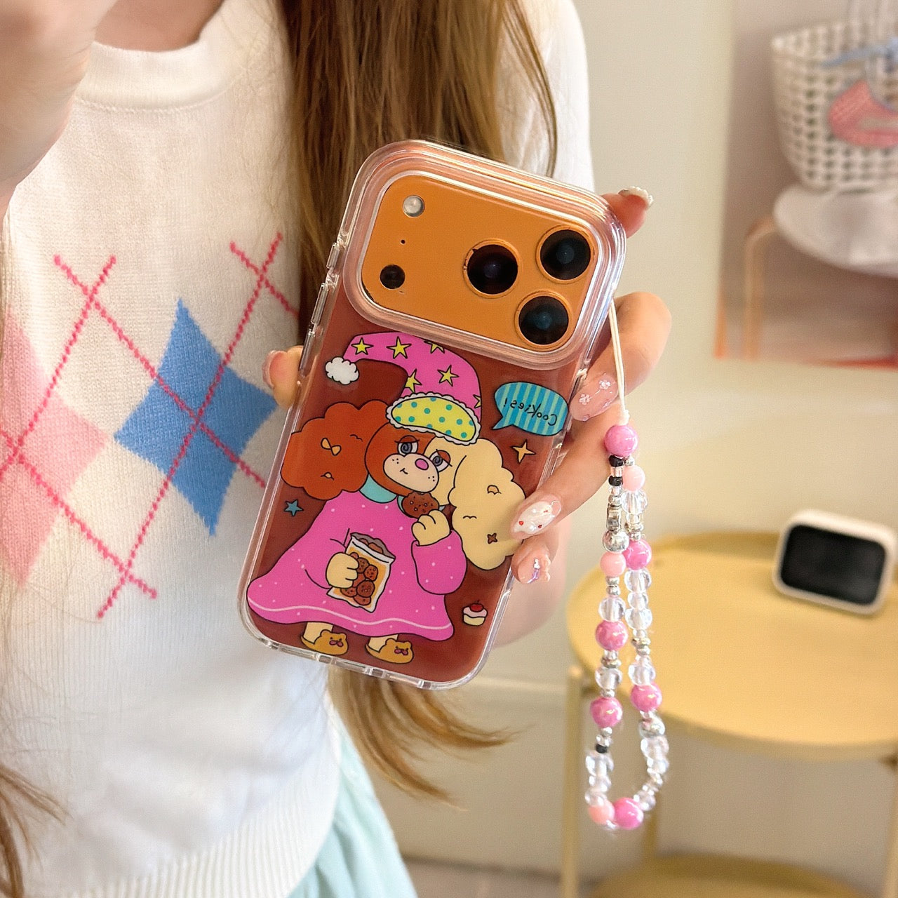 A hand holding a cute pajama dog phone cover featuring an orange metallic lens protection frame.