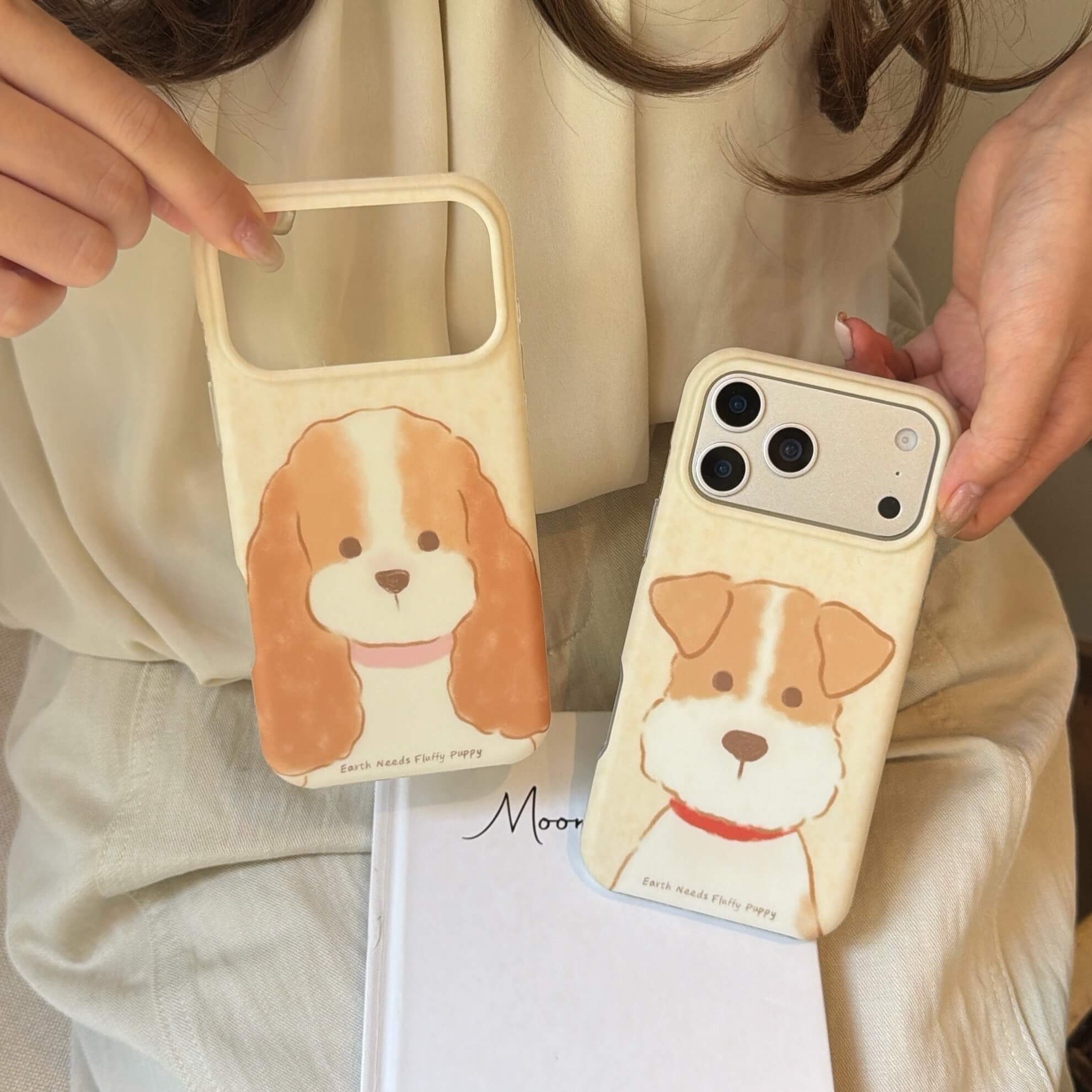 Two cream puppy iPhone case styles showing different camera frame sizes.
