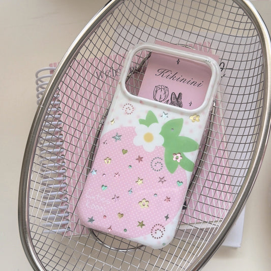 A cute pink strawberry phone case placed inside a silver metal wire basket over a pink spiral notebook.