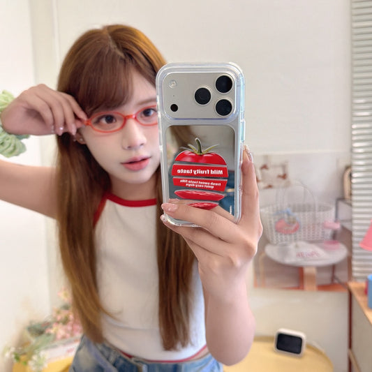 Girl taking a mirror selfie holding a cute tomato graphic mirror phone case with an orange camera frame.