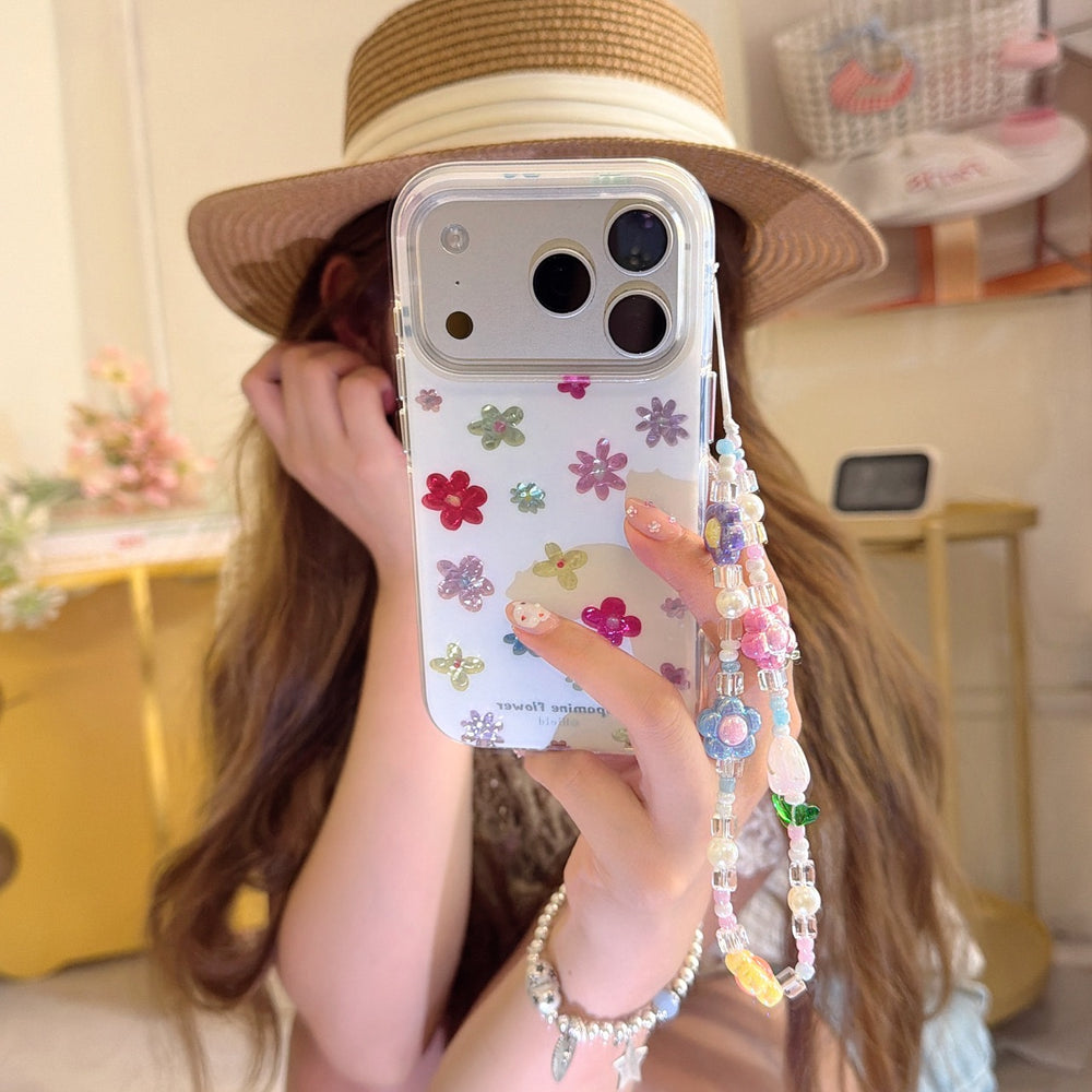 A girl wearing a straw hat holds a clear dopamine flower phone case with a colorful beaded wrist strap.