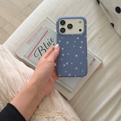 A close-up view of a hand holding the blue textured star iPhone case showing its raised camera frame.