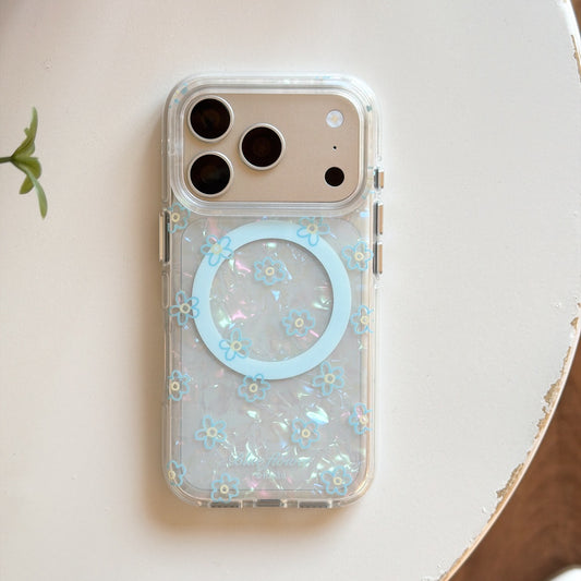 Product shot of an isolated iridescent pearl-texture phone case with blue flower print and a matching 3D flower phone stand.