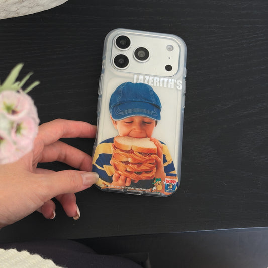 A hand touching a funny boy sandwich clear iPhone case on a black table with a pink flower.