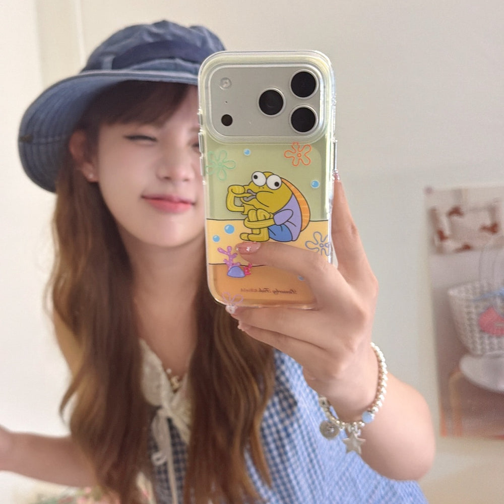 A young woman taking a mirror selfie holding a funny cartoon fish iPhone case with an orange background.