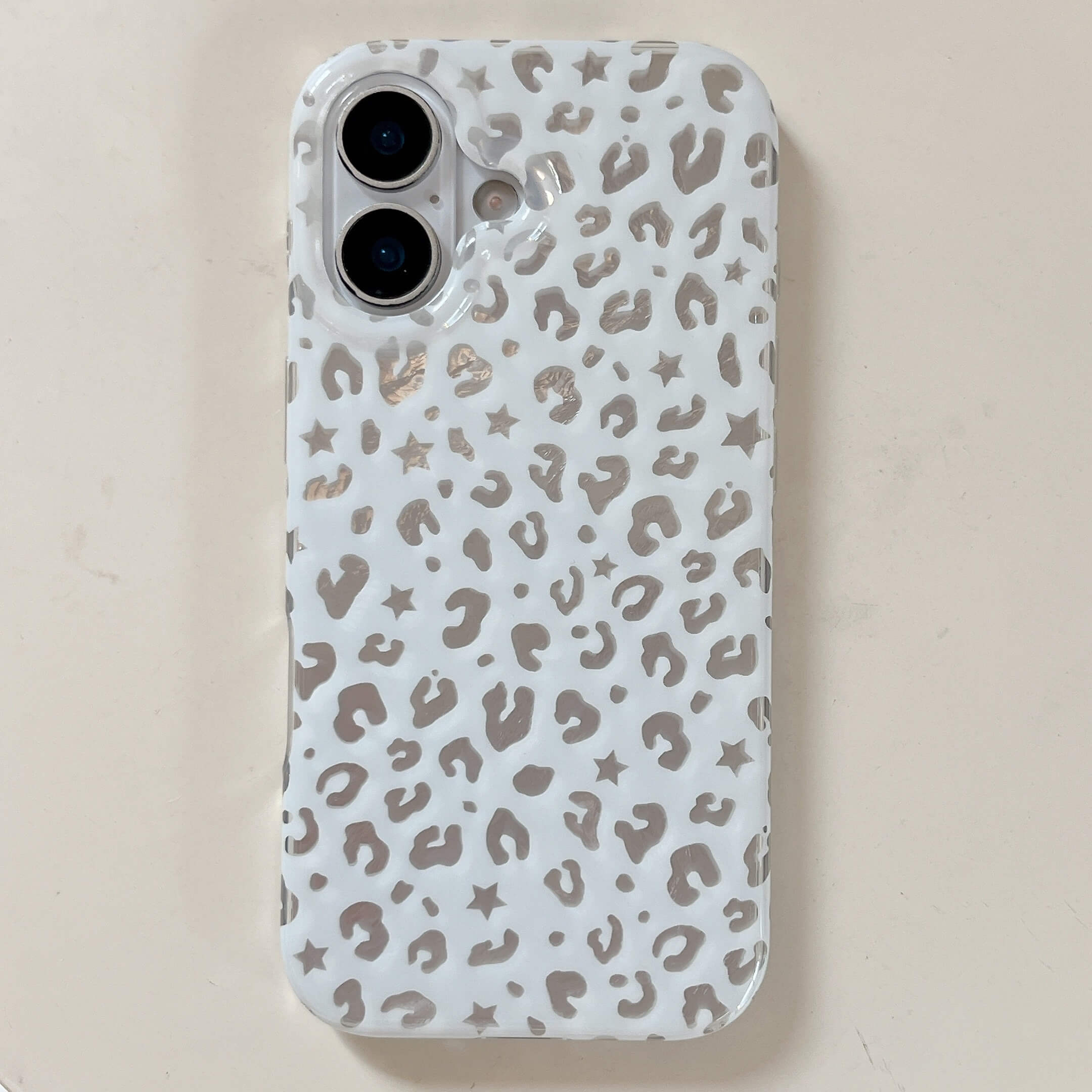 White glossy iPhone case with reflective silver foil leopard print and star details.