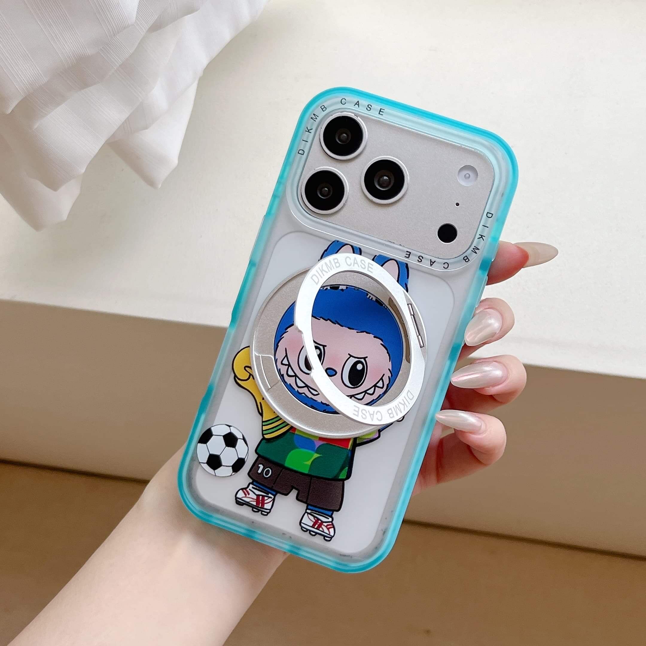 A hand holding a Labubu kickstand phone case with the silver ring partially opened.