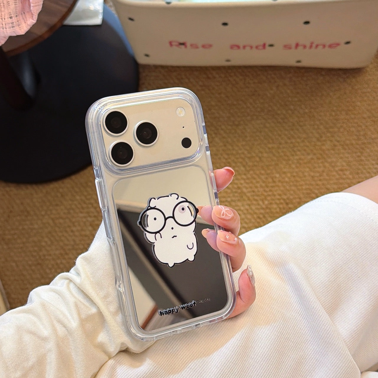 Close-up of a hand holding a clear HD mirror iPhone case with a cute nerd animal print.