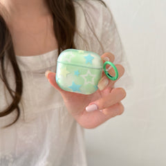 A close-up of a person holding a kawaii mint green star AirPods case against a white dress.