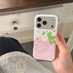 A person holding a kawaii pink strawberry iPhone case with a silver lens protector area against a vintage white wooden drawer.