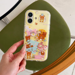A hand holding a clear shockproof phone case with cute bear sticker-style graphics over a green chair background.