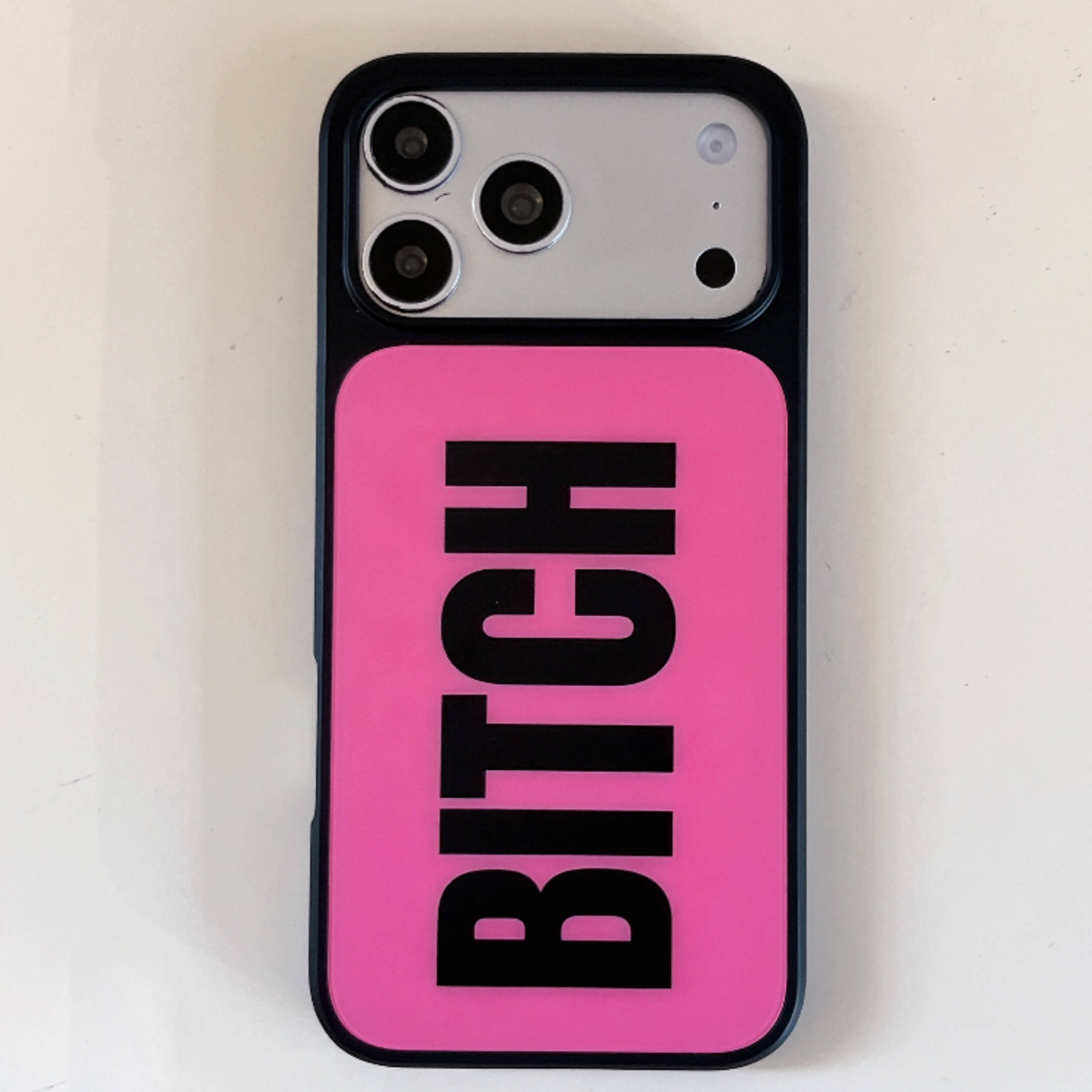 Full vertical back view of a hot pink phone case featuring a bold black typography design