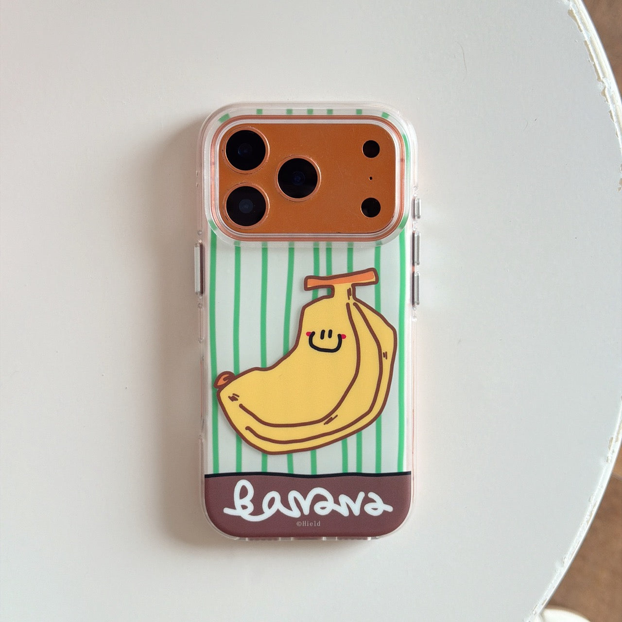 Product shot of an isolated aesthetic banana striped phone case for a bronze iPhone model on a white background.