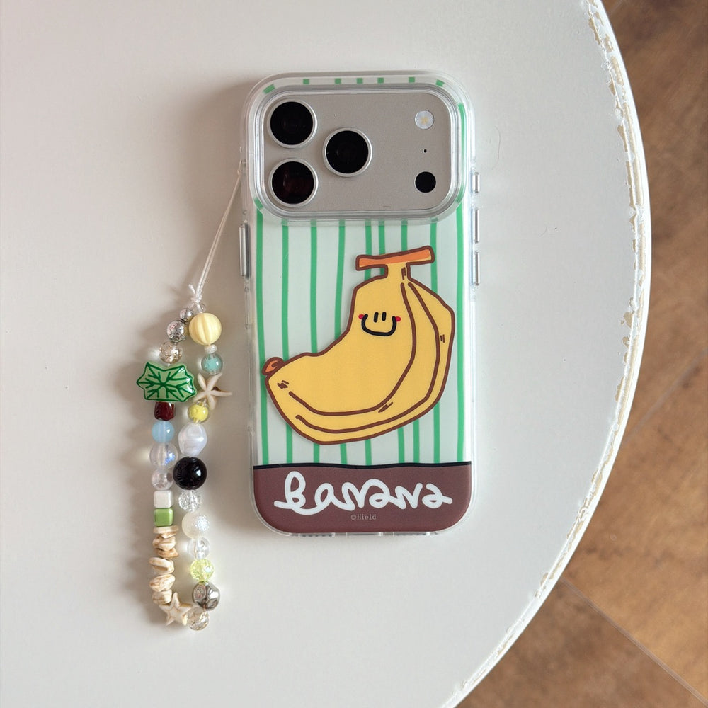 Product shot of an isolated cute green striped banana phone case with a colorful beaded hand strap on a white table.