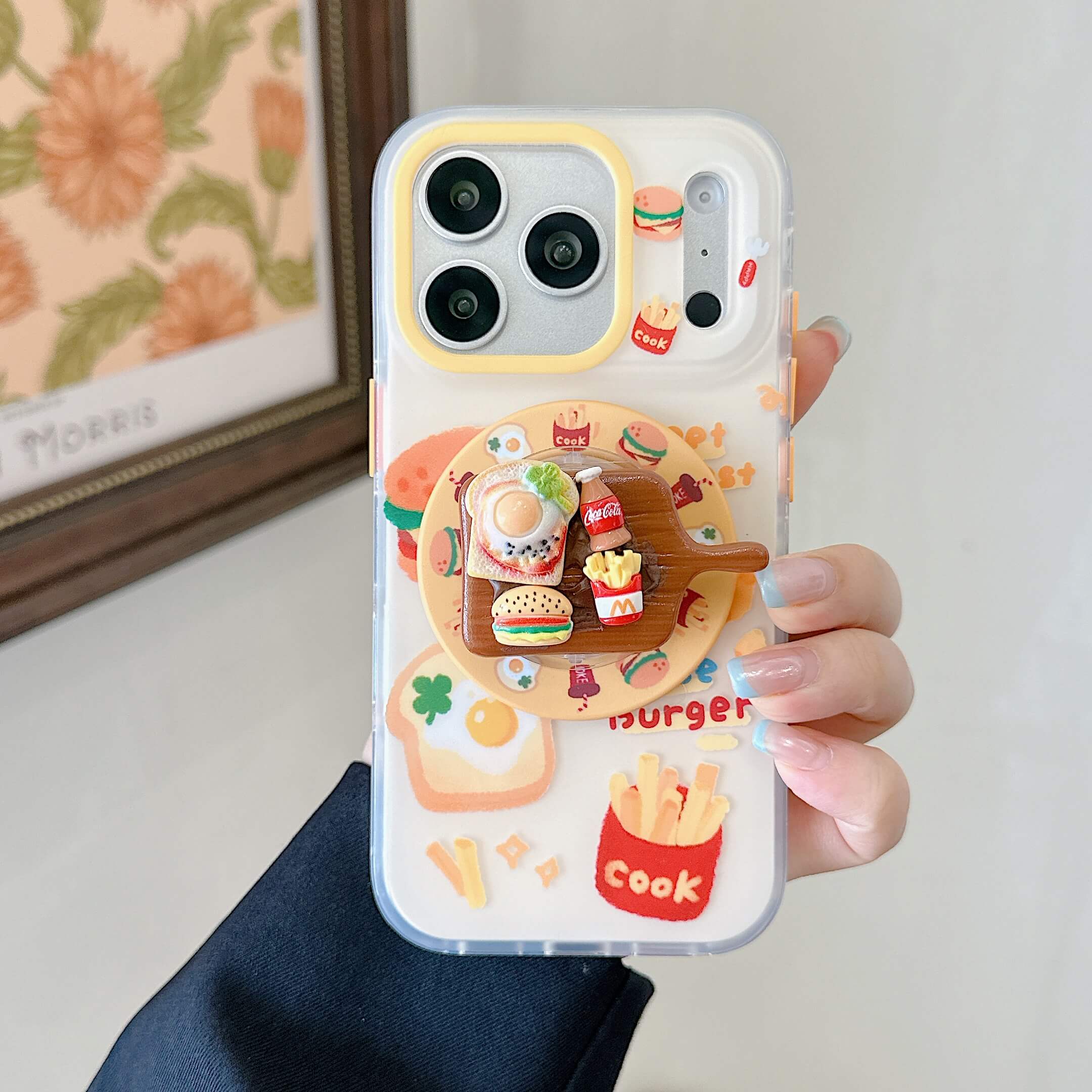 Close-up of a hand holding the clear kawaii phone case featuring a 3D breakfast platter pop grip stand.