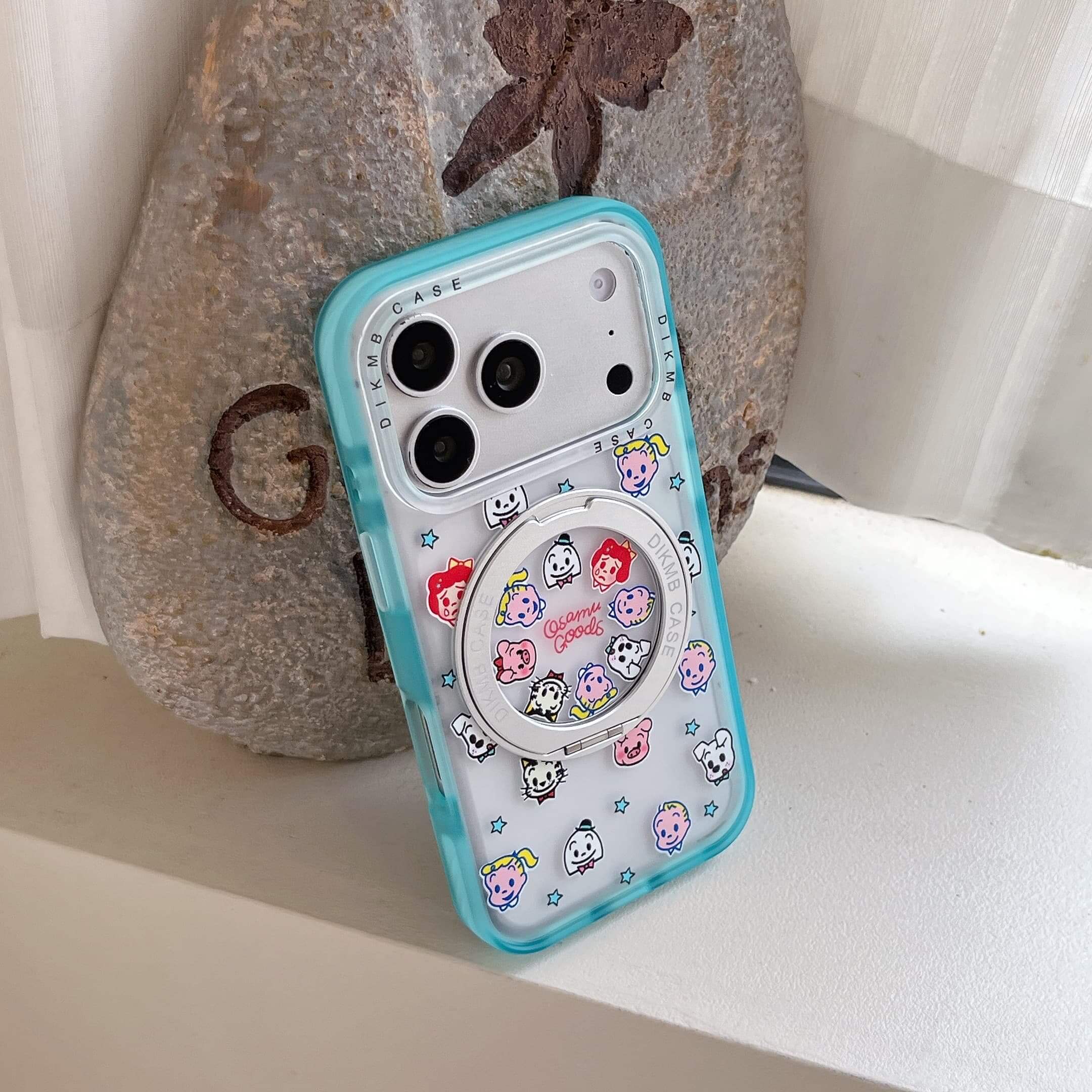 A person with elegant pearl nails holding a kawaii cartoon phone case horizontally.