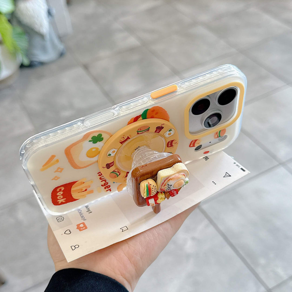 The clear kawaii food phone case propped up horizontally on a table using its 3D breakfast pop grip.